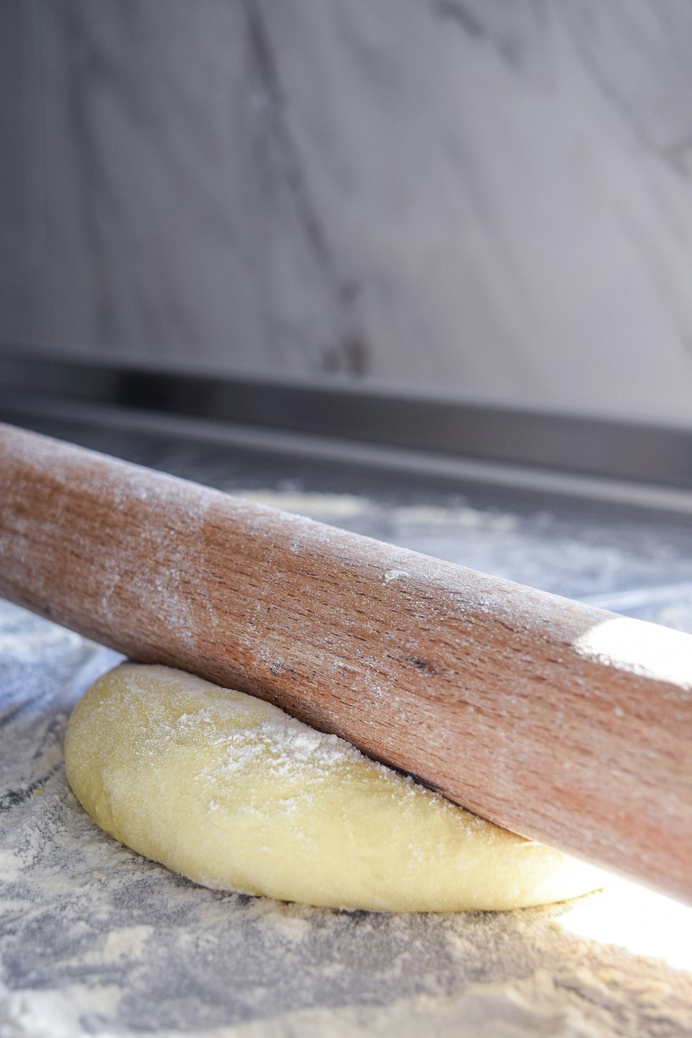 brown wooden rolling pin on gray metal surface