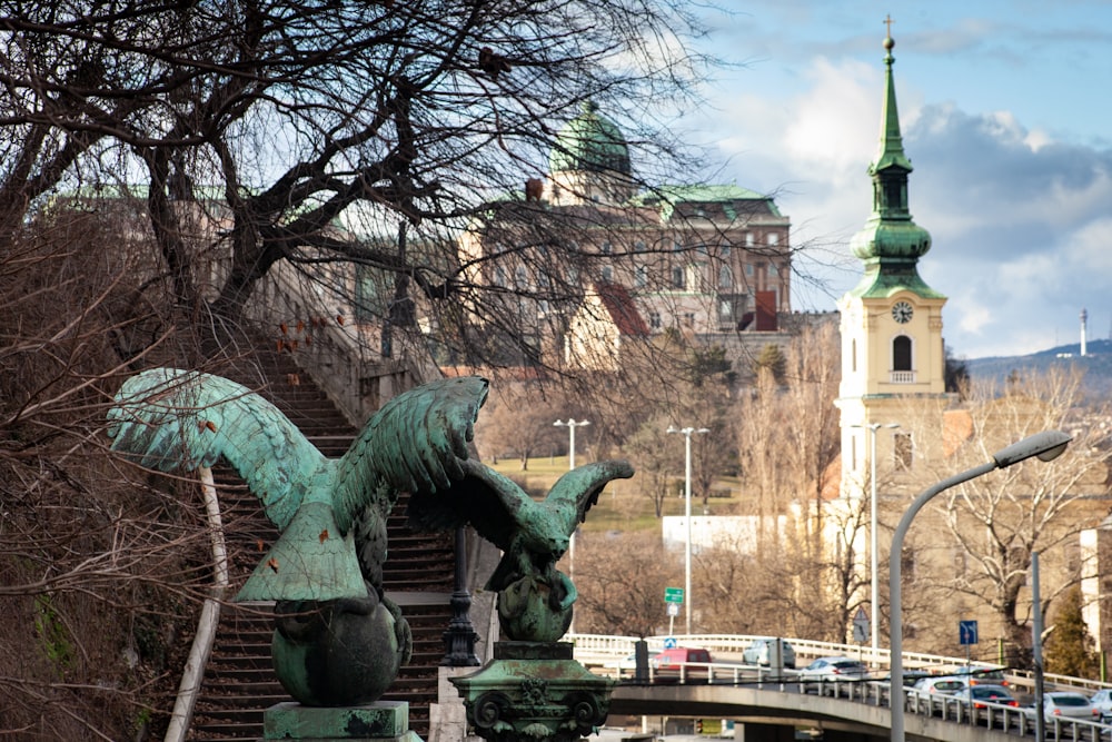 green dragon statue near brown bare trees during daytime