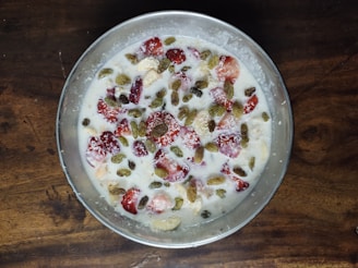 Close-up of a creamy no-cook filling in a glass bowl with fresh fruits around.