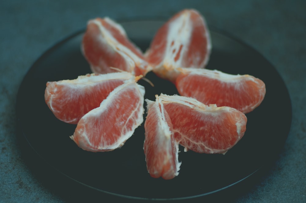 sliced red fruit on black plate