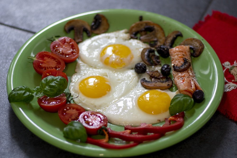 sunny side up egg with sliced tomato on green ceramic bowl