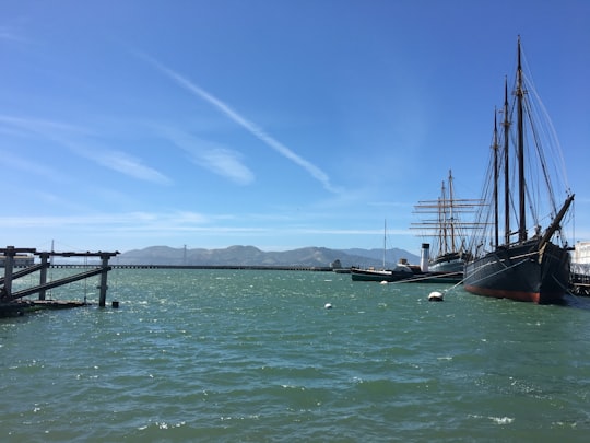 black ship on sea under blue sky during daytime in San Francisco Maritime National Historical Park United States