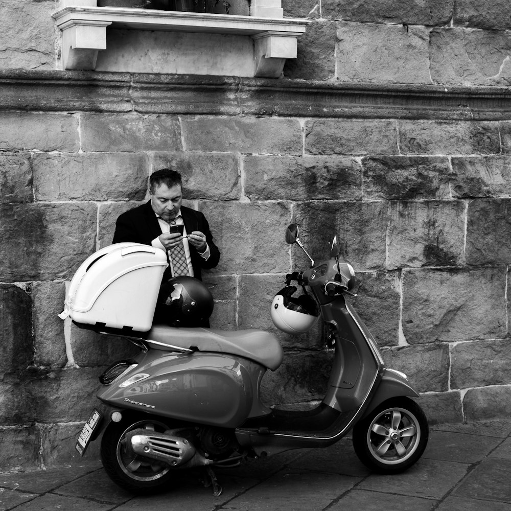 woman in black and white long sleeve shirt sitting on black and white motor scooter