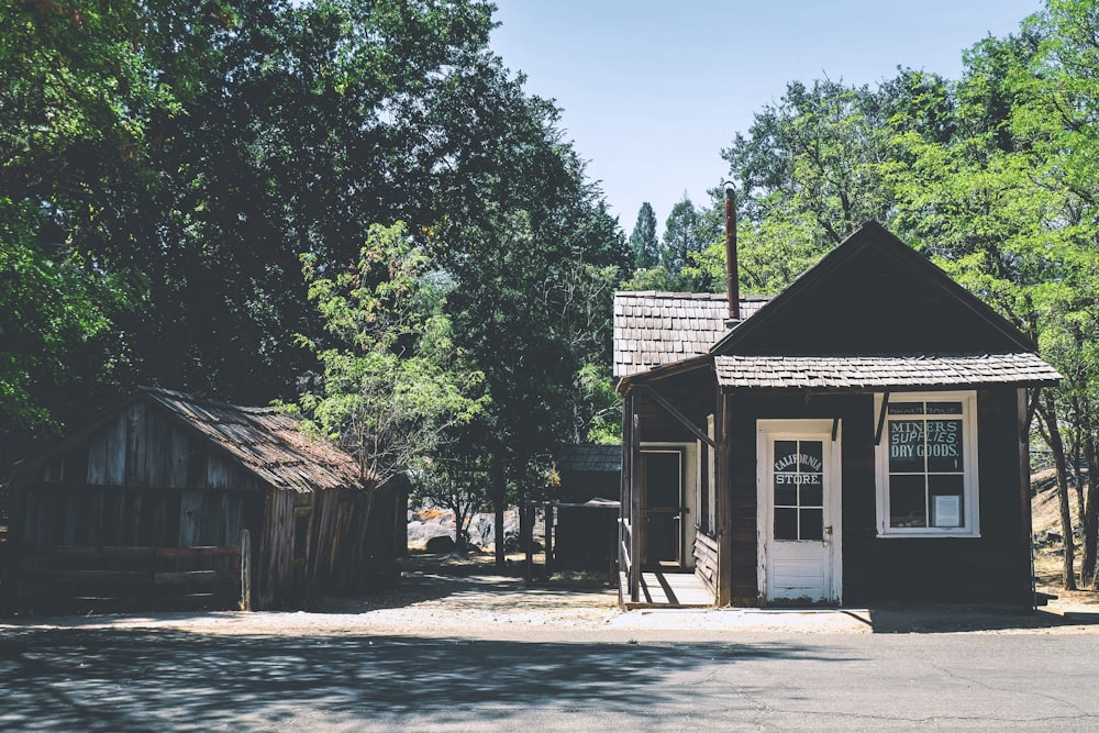 brown wooden house near green trees during daytime