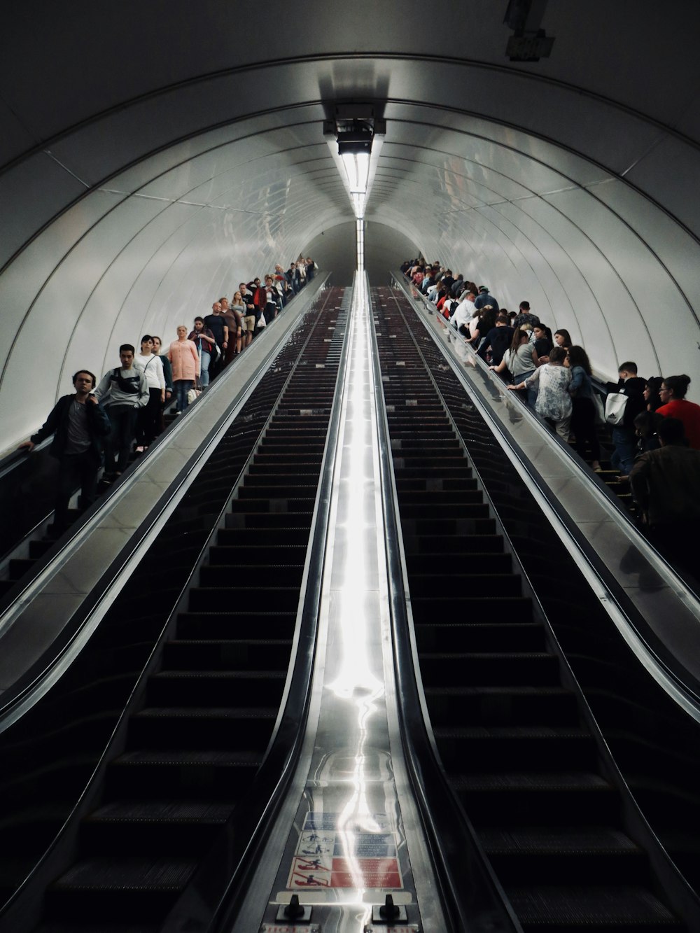 people walking on escalator inside building