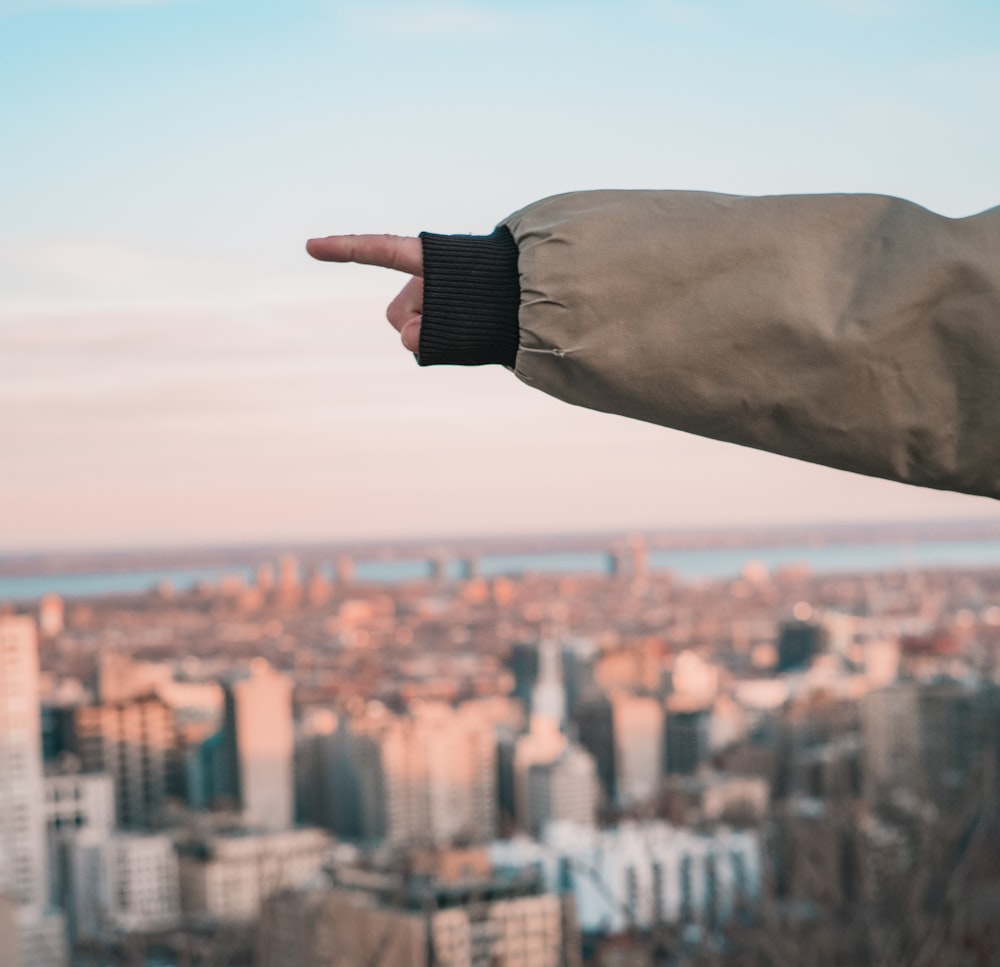 person in brown jacket standing on top of building during daytime