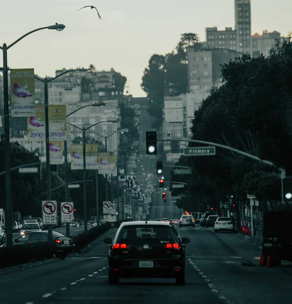 black car on road near city buildings during daytime