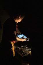 man in red shirt and brown pants holding tablet computer
