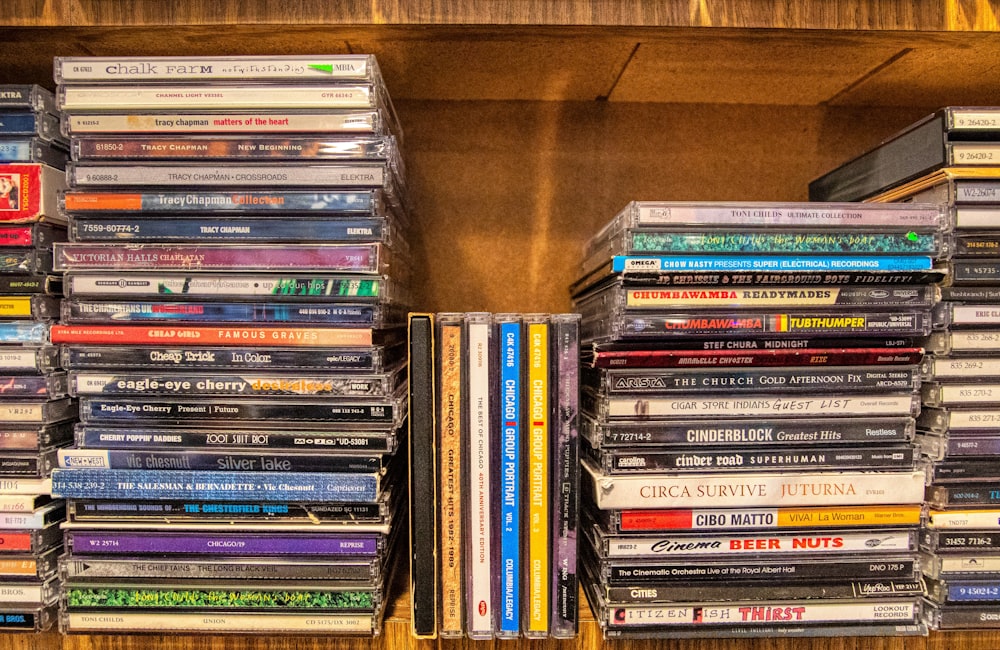 assorted cd case on brown wooden shelf