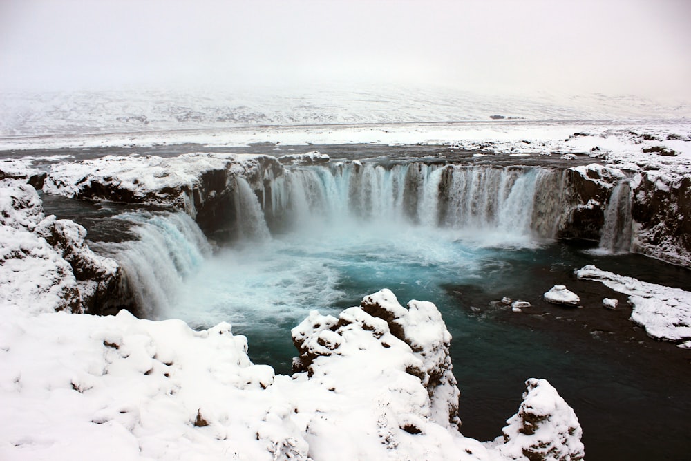 a frozen waterfall in the middle of a snowy landscape