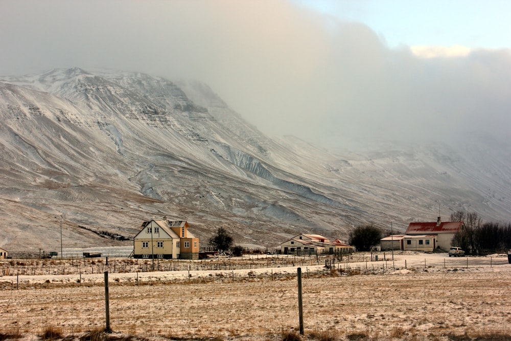 a snow covered mountain with houses in the foreground