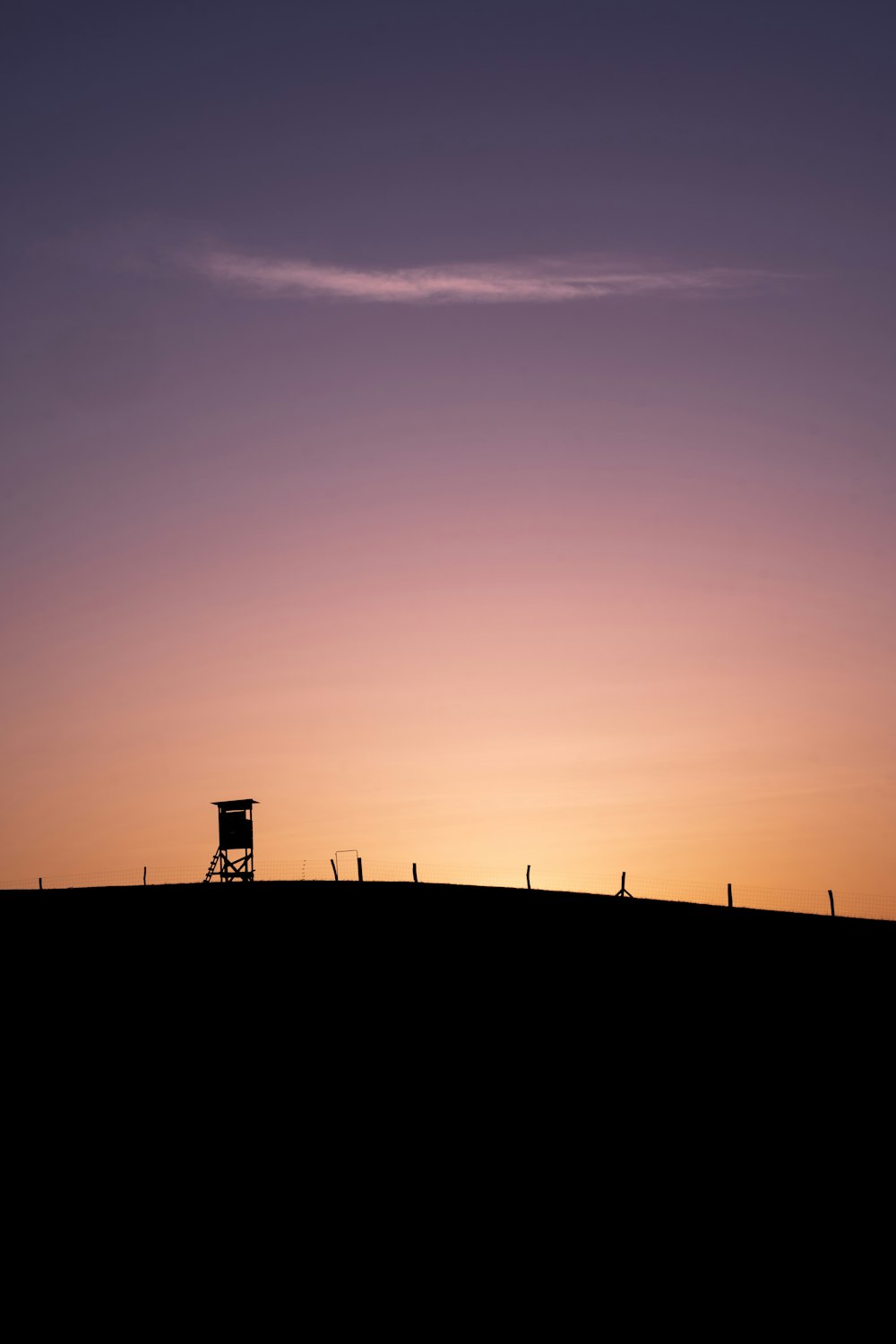 silhouette of people standing near white building during sunset