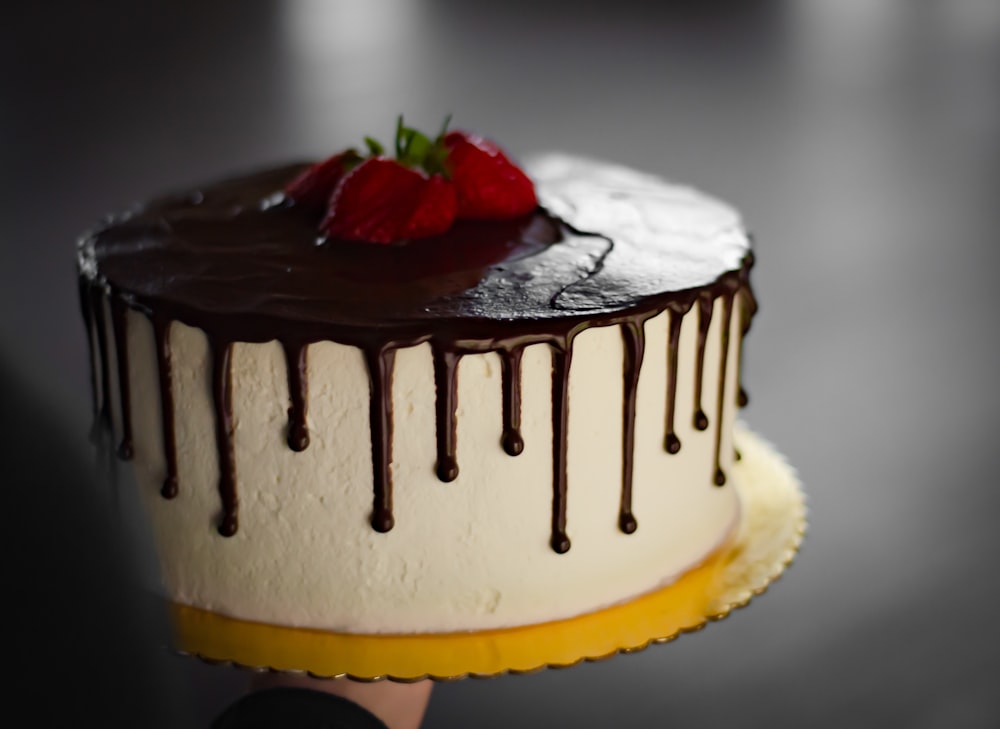 gâteau brun et blanc avec fraise sur le dessus