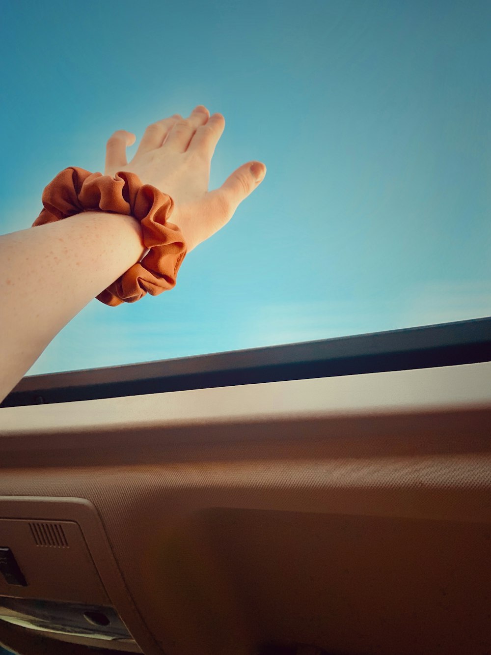 persons left hand on car dashboard
