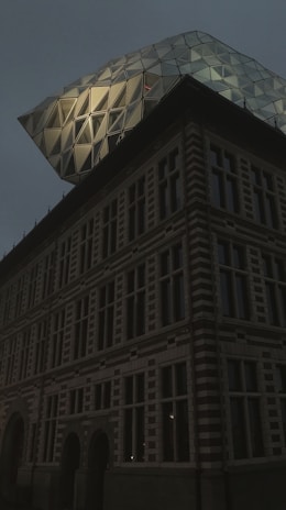 A historic office building in Finland with a modern glass extension symbolizing growth.