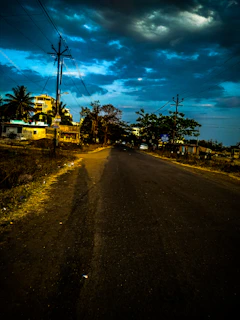 A freshly paved road with modern street lighting in Ambato at sunset.