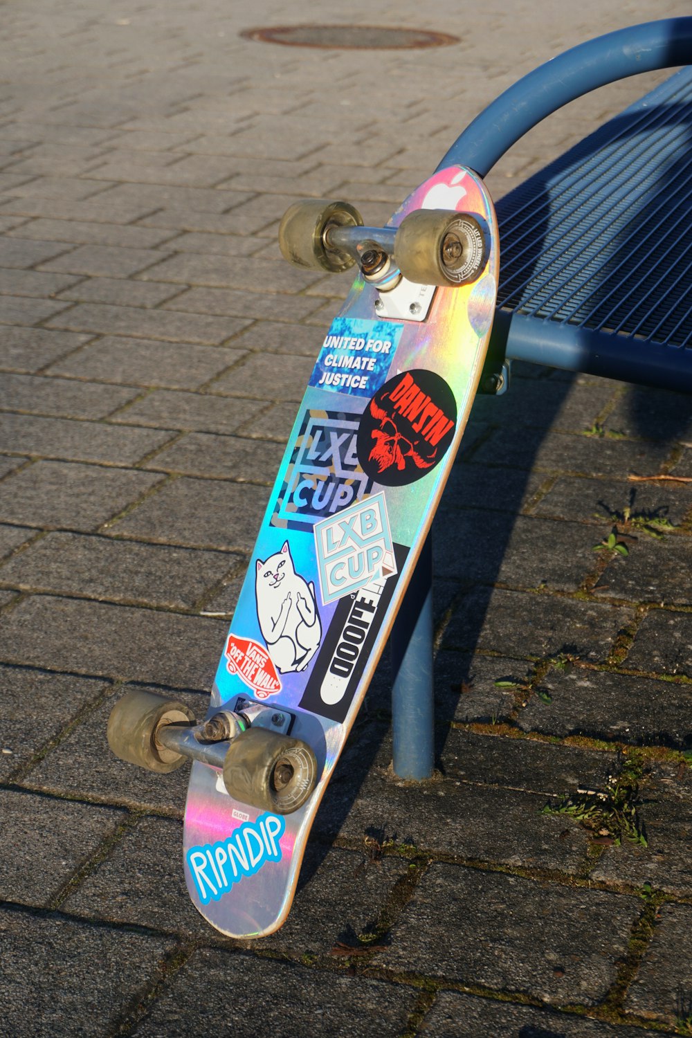 blue and white skateboard on gray metal fence