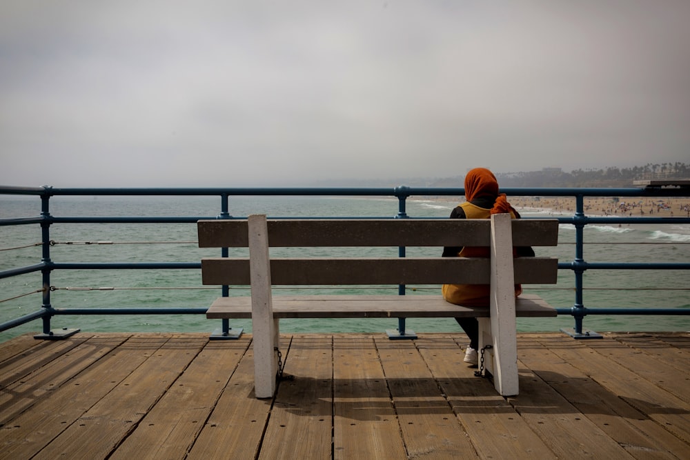 brown wooden bench near body of water during daytime