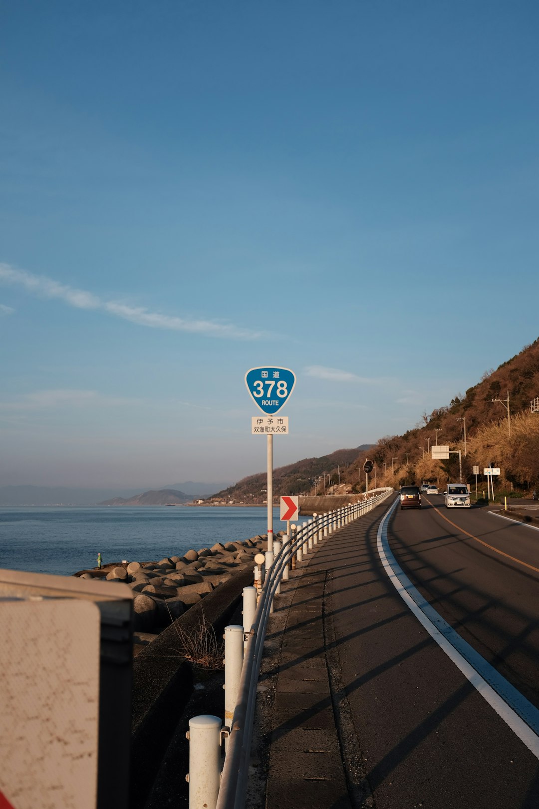 road sign near body of water during daytime