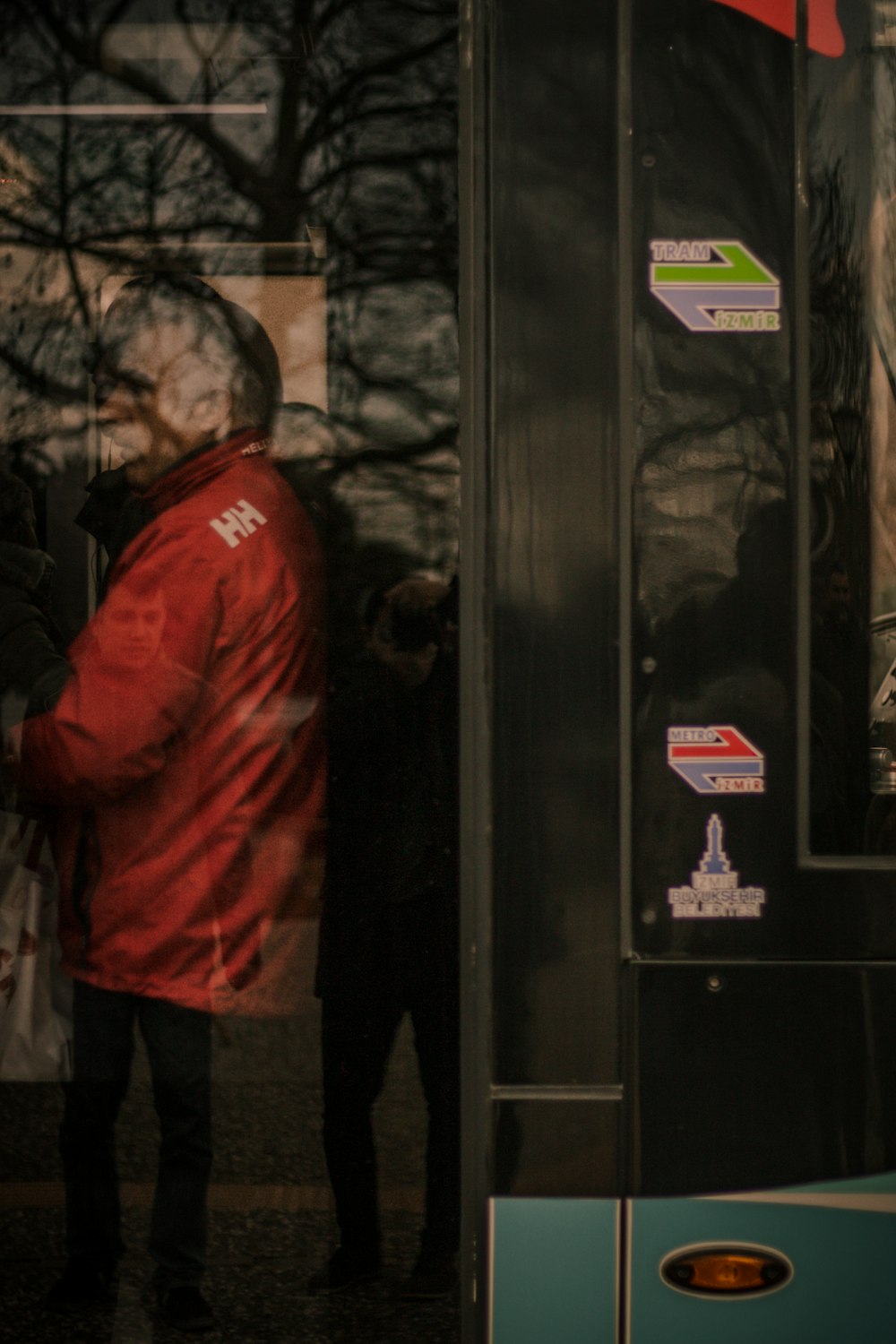 man in red jacket standing near black door