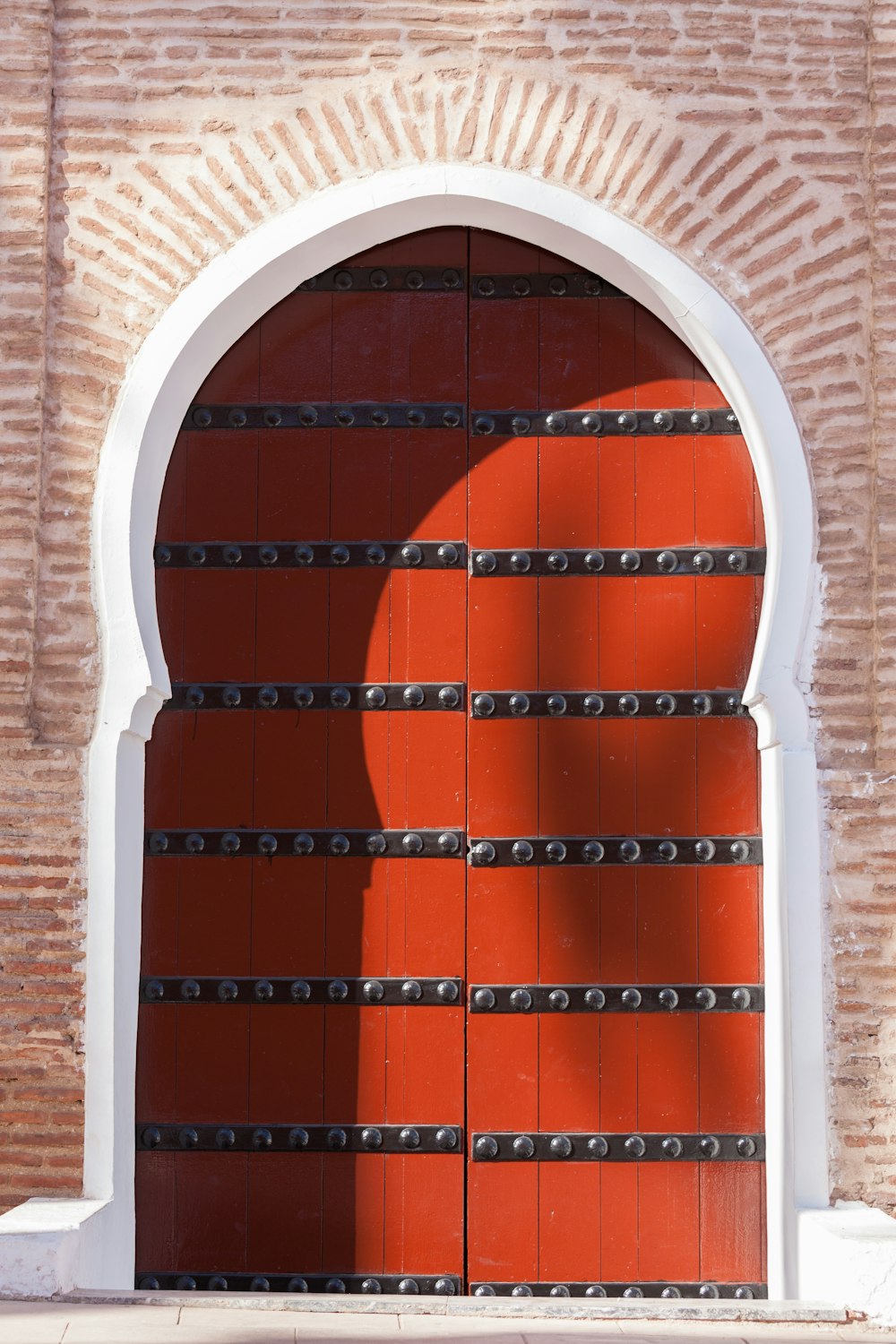 Grille de fenêtre en métal bleu sur un mur de briques brunes