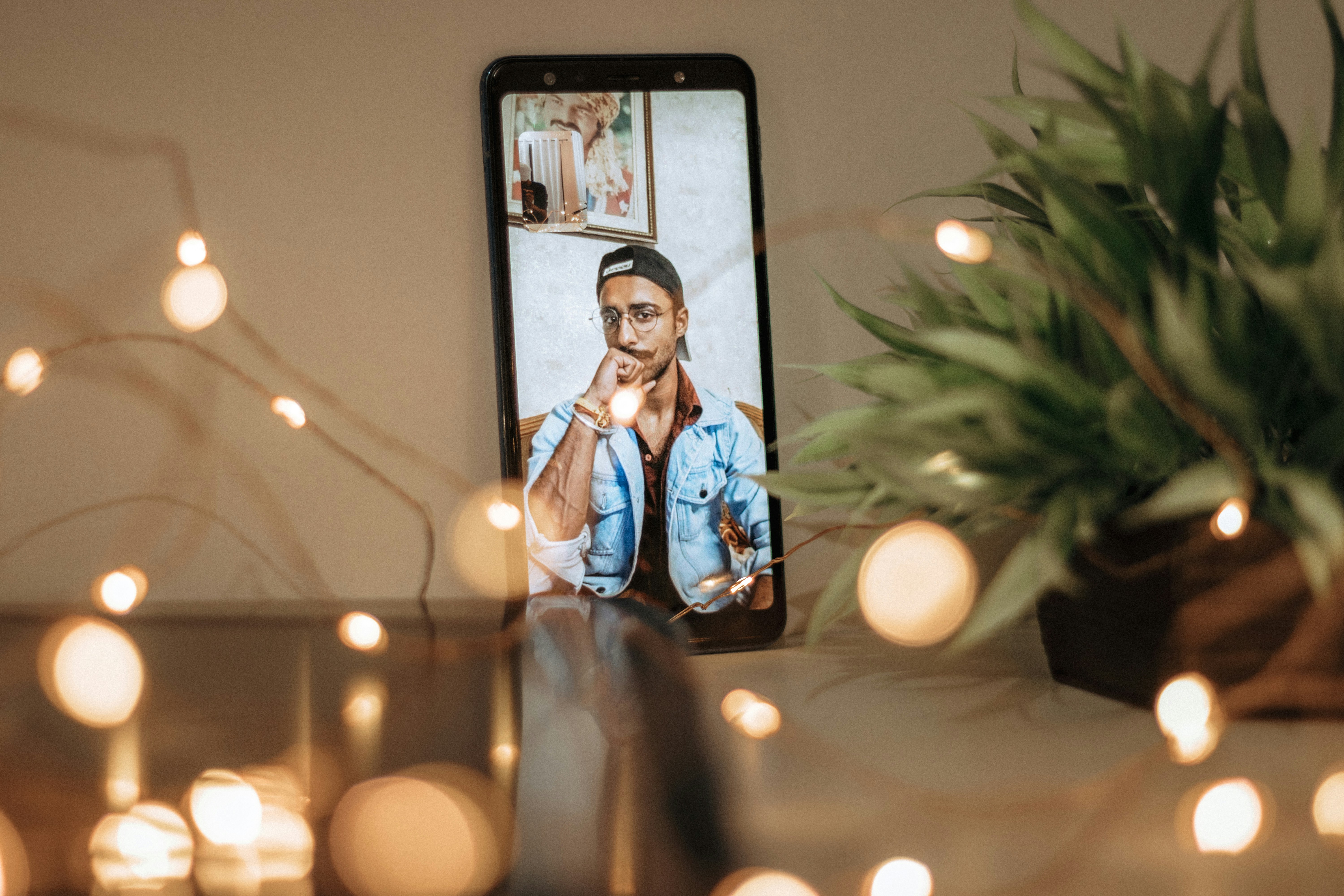 A smartphone on a table showing a video call with a man