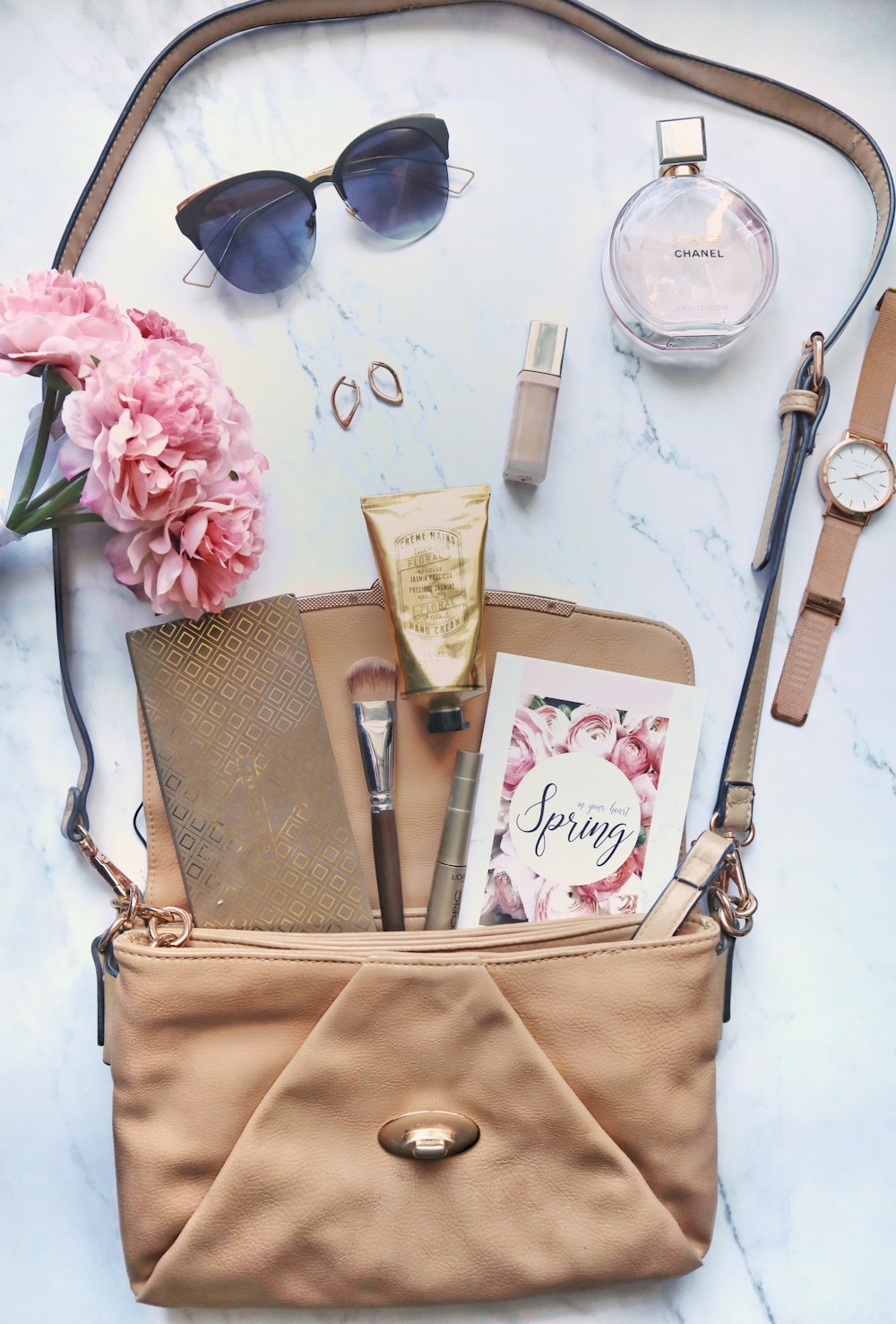 gold and silver watch beside brown leather sling bag