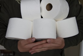 person holding white toilet paper roll