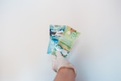 Close-up of hands exchanging money with a transparent overlay of a Canadian map.