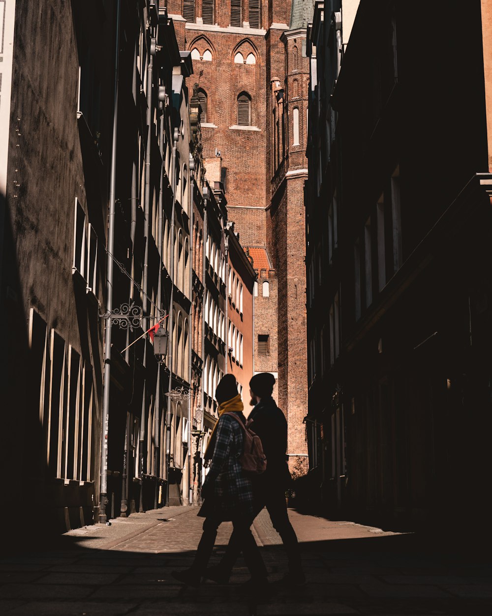 man in black jacket walking on street during daytime