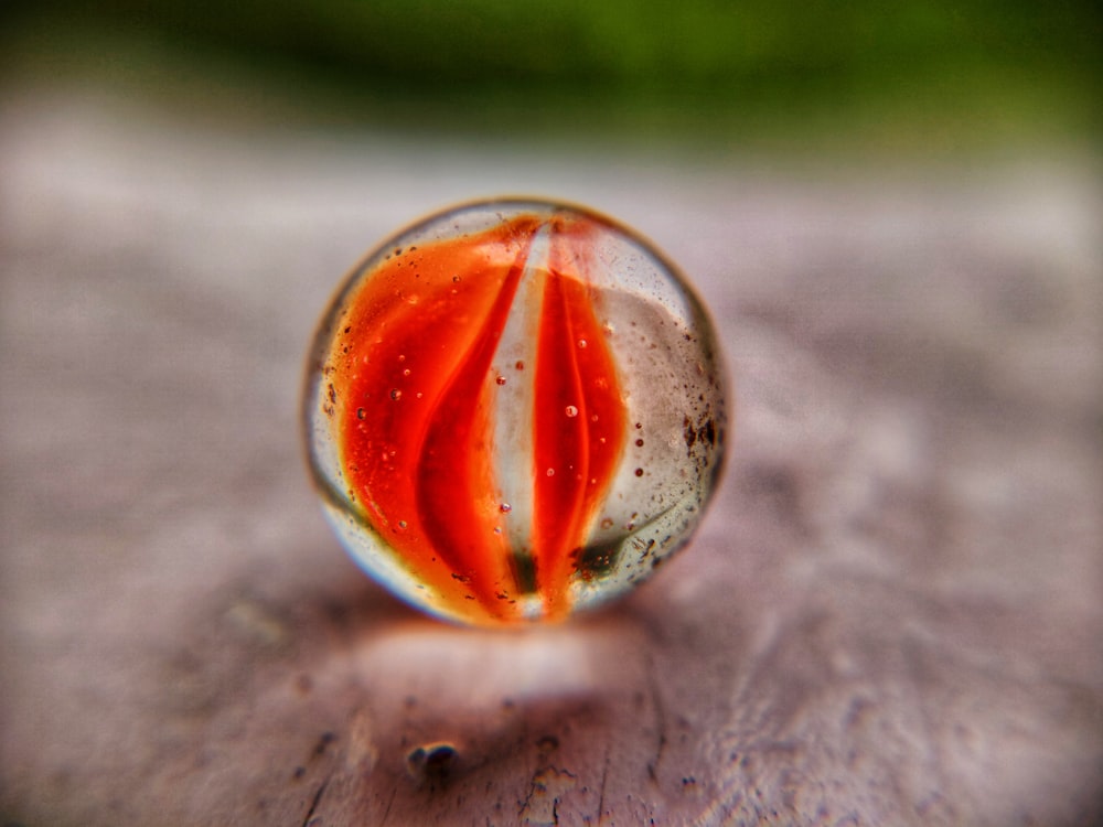 red and clear glass ball on gray textile