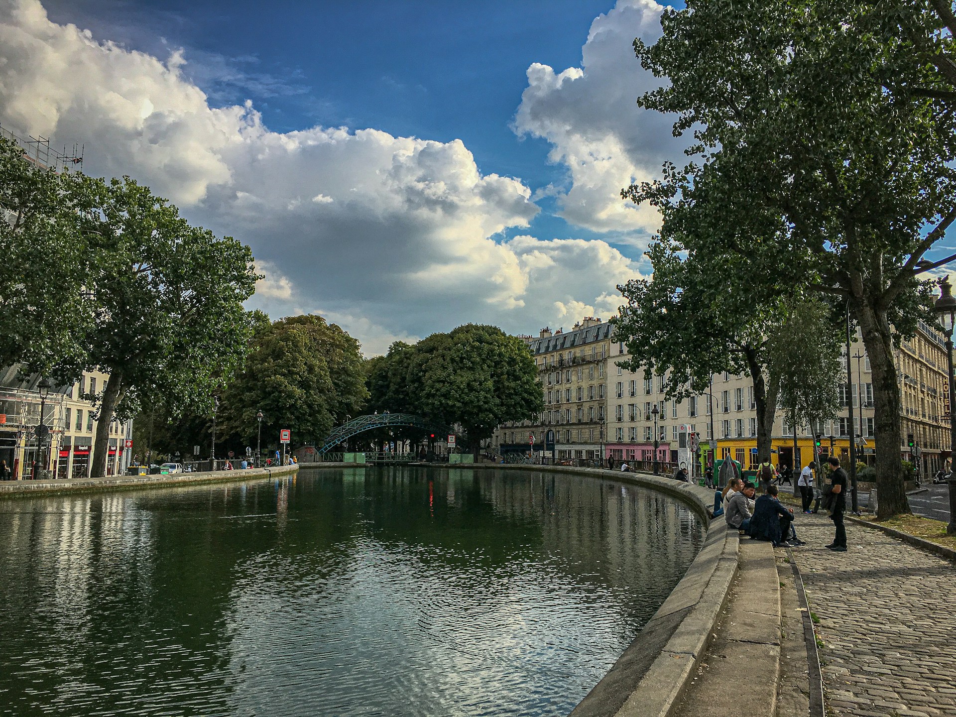 people walking on sidewalk near river during daytime