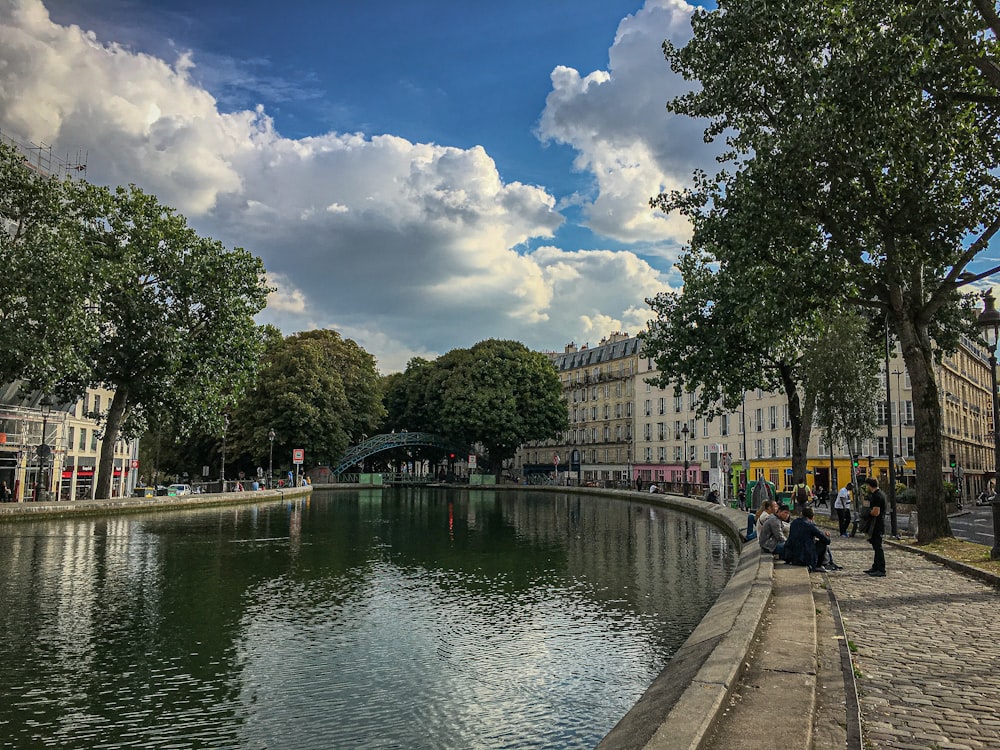 people walking on sidewalk near river during daytime