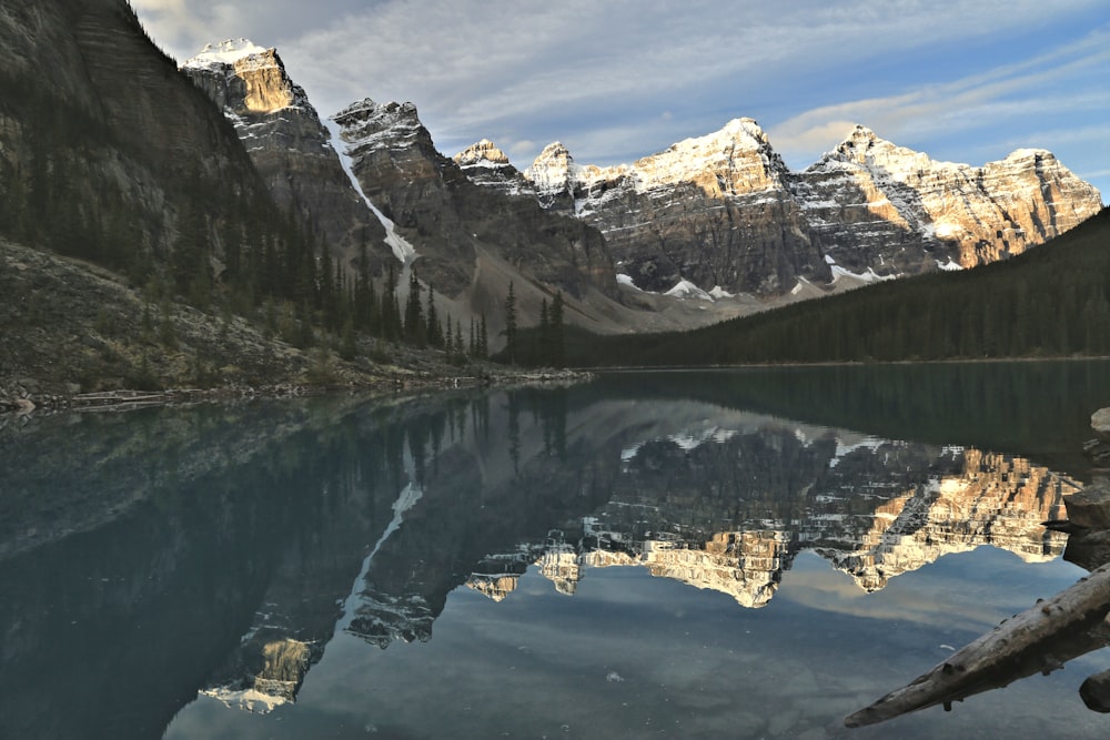 snow covered mountain near body of water during daytime