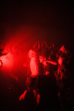 Crowd dancing under dynamic lighting at a techno party.