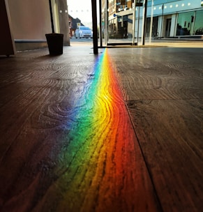 A warm, inviting office entrance with colorful rainbow decorations reflecting the company name.