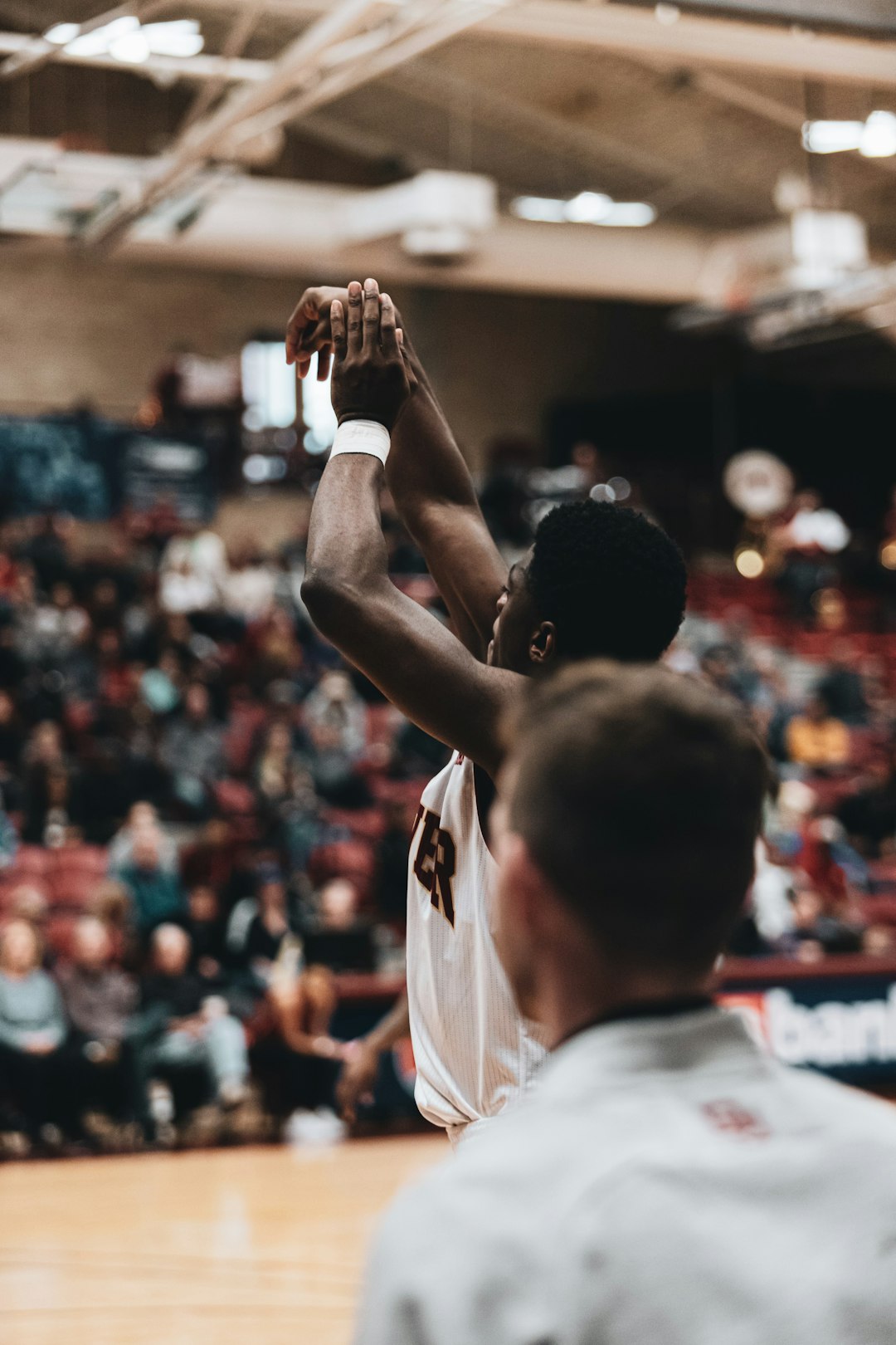 man in white jersey shirt raising his hands