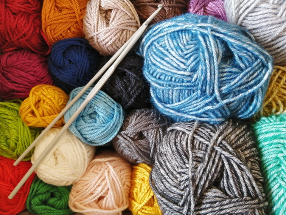 colorful yarn alongside knitting needles