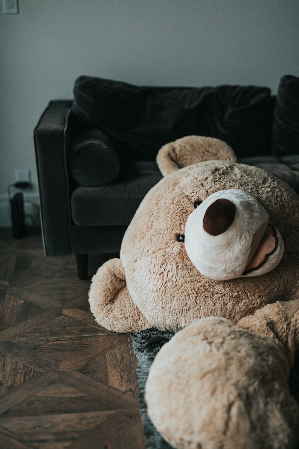 brown and white dog plush toy on black couch