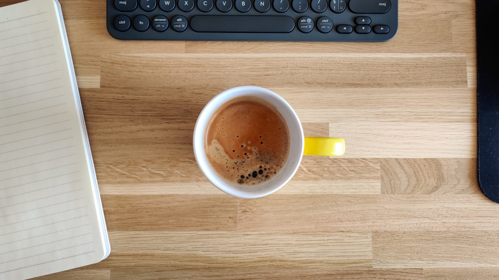 Taza de cerámica amarilla sobre mesa de madera marrón