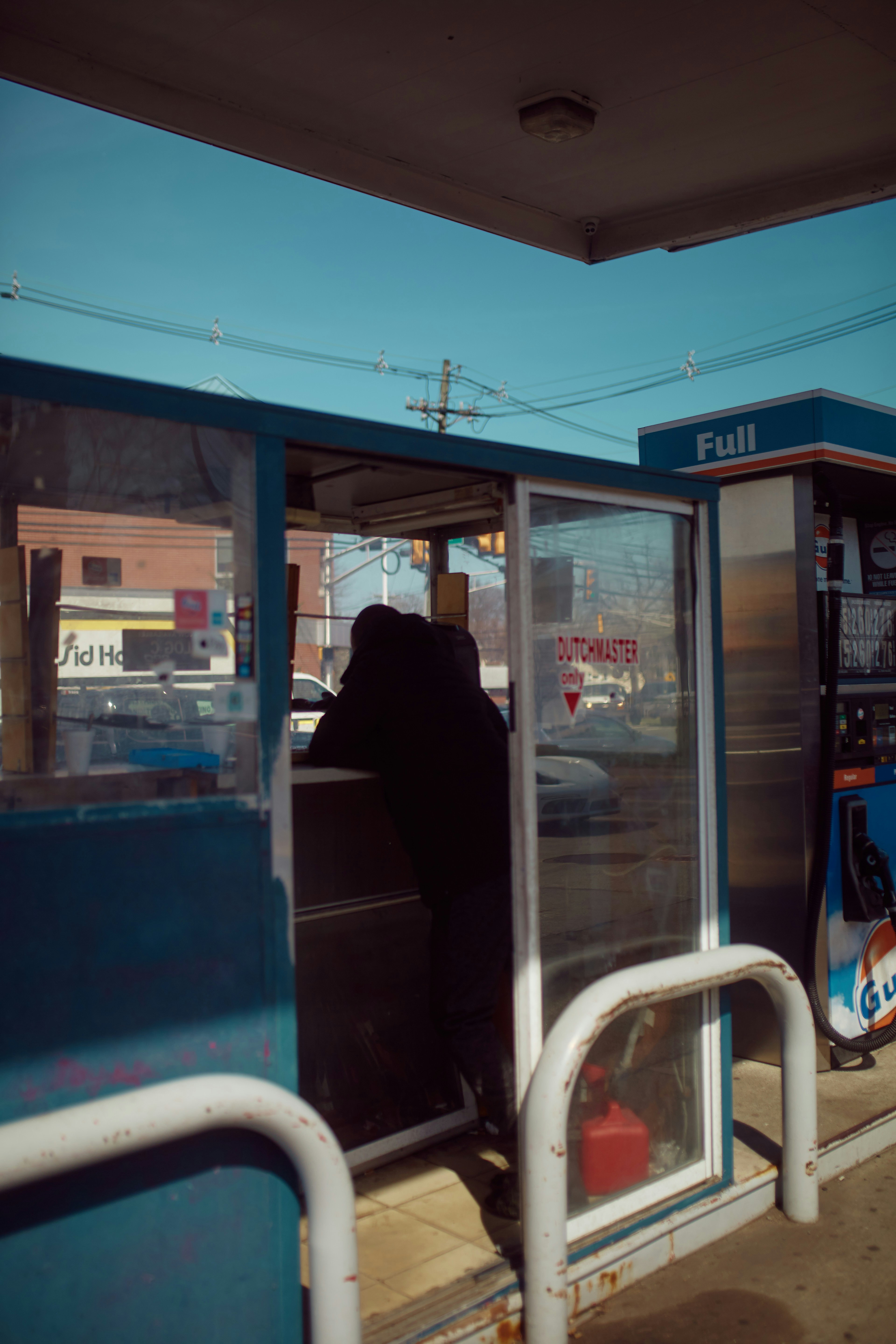 man in black jacket standing near glass door