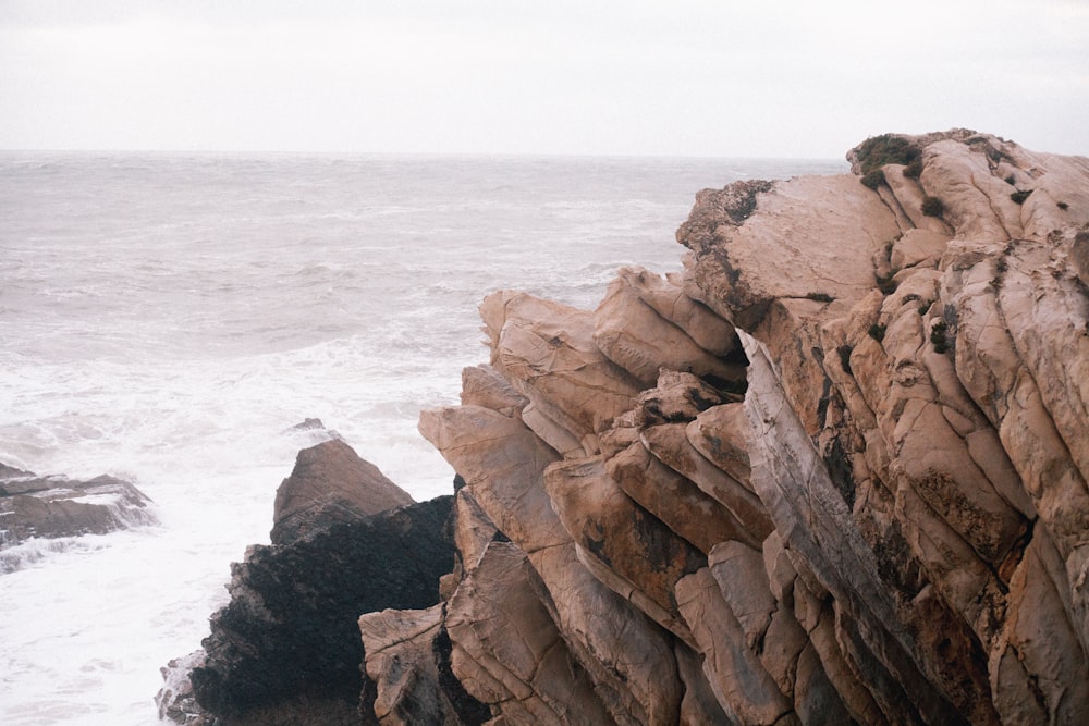 brown rock formation near body of water during daytime