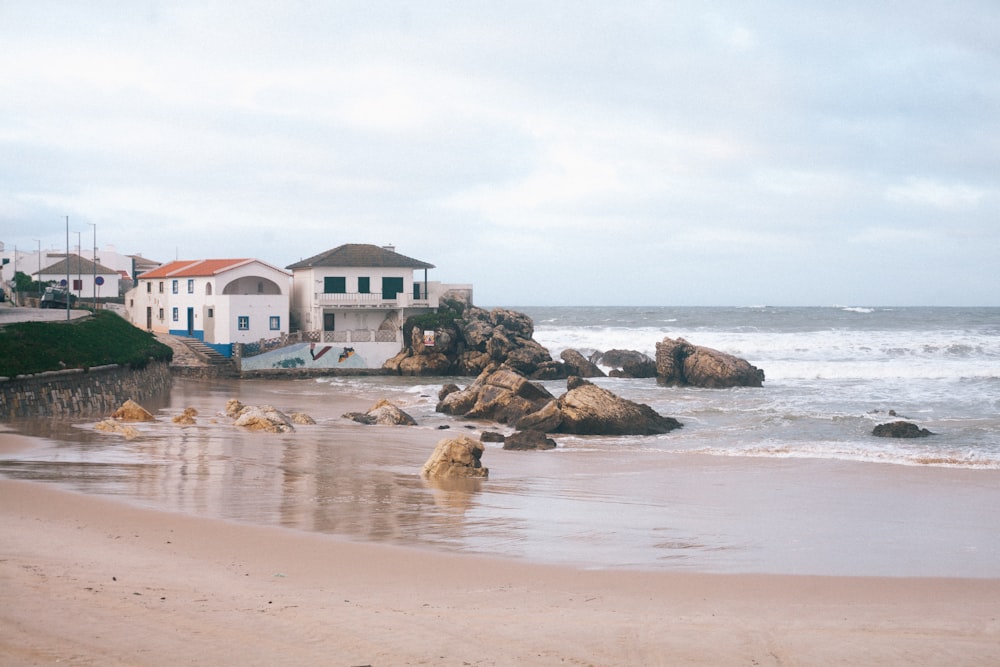 white and brown houses near sea under white clouds during daytime