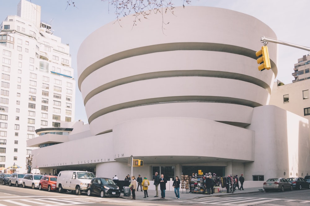 people walking on street near white concrete building during daytime