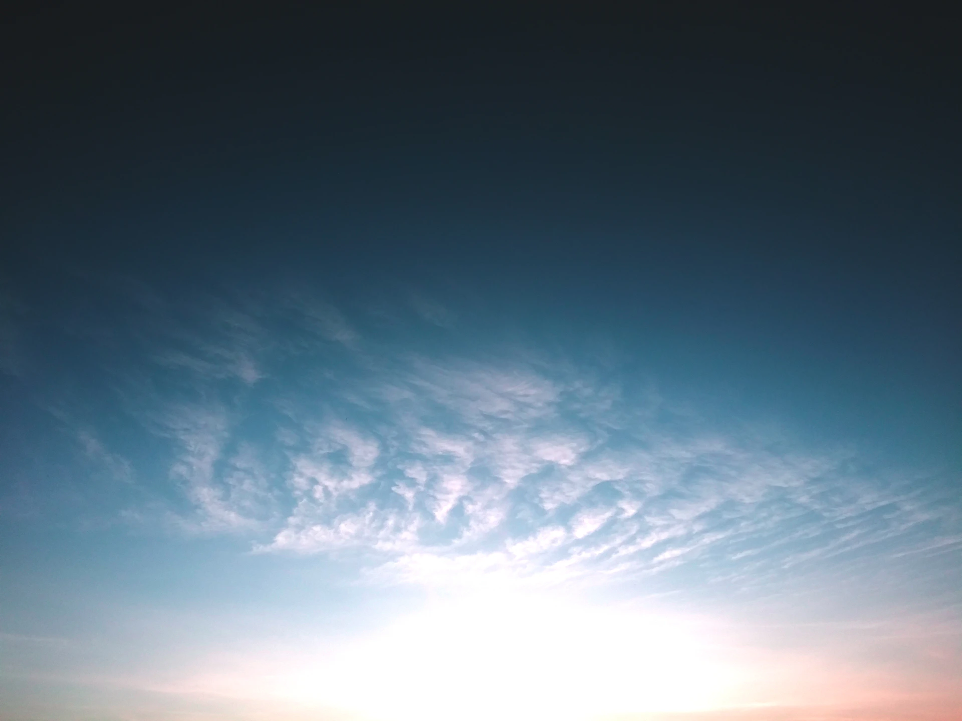 A bright, expansive sky with a small glowing sun near the horizon, evoking the 'céu em movimento' concept with soft blue and white tones.