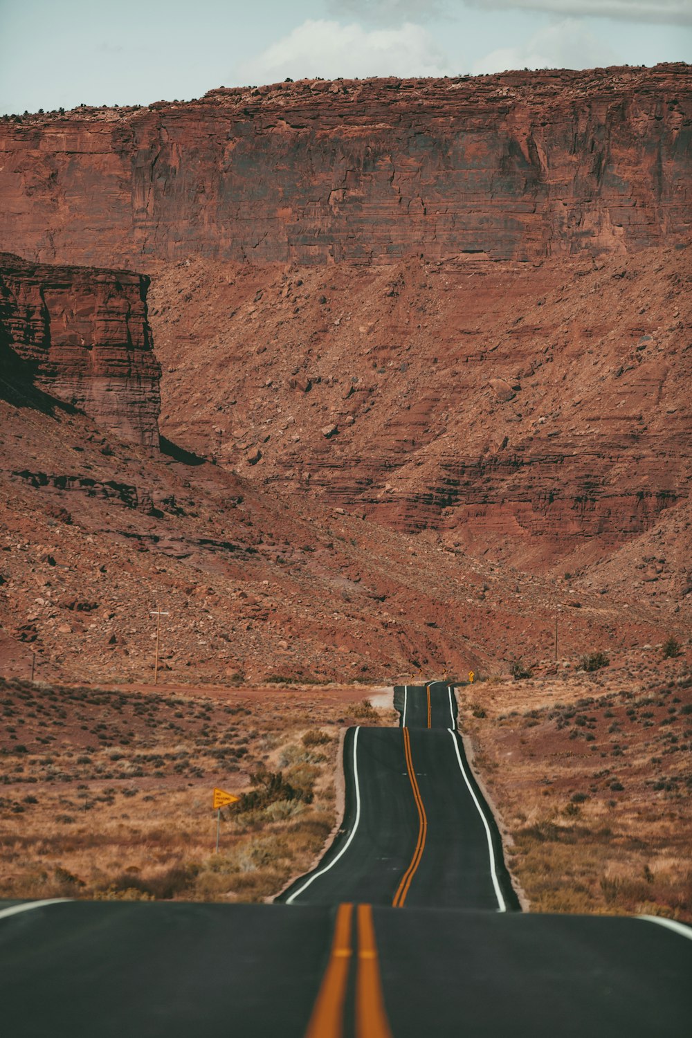 white car on road near brown rock formation during daytime