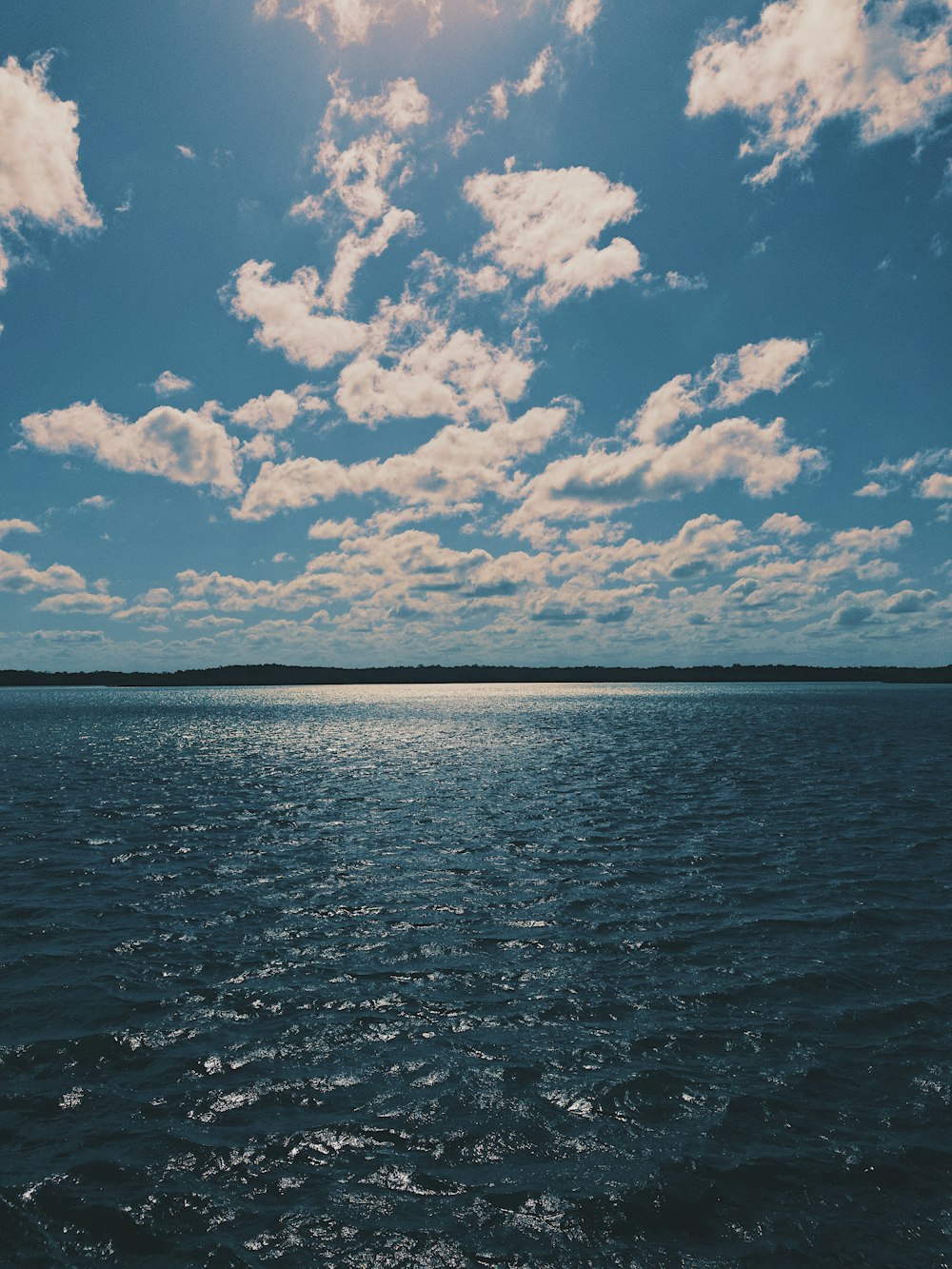 blue sea under blue sky and white clouds during daytime