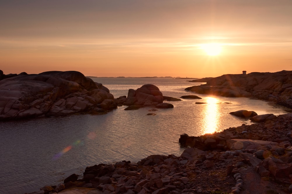 brown rock formation on body of water during daytime