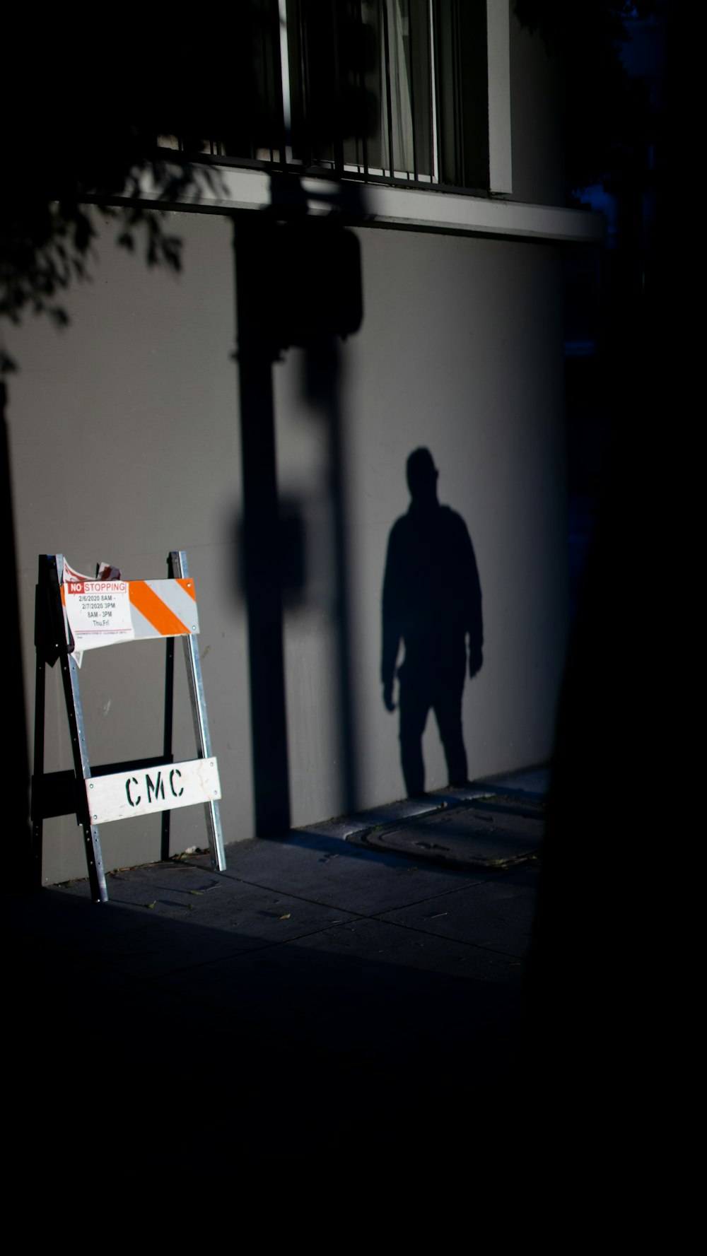 man in black coat walking on sidewalk during daytime