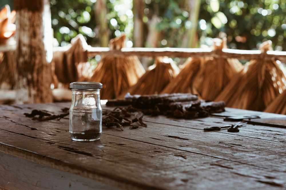 bottiglia di vetro trasparente su tavolo di legno marrone
